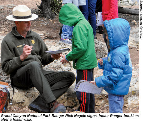 Ranger Rick Negele signs Junior Ranger booklets in Grand Canyon National Park.
