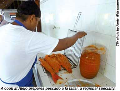 A cook at Alejo prepares pescado a la taller, a regional specialty.