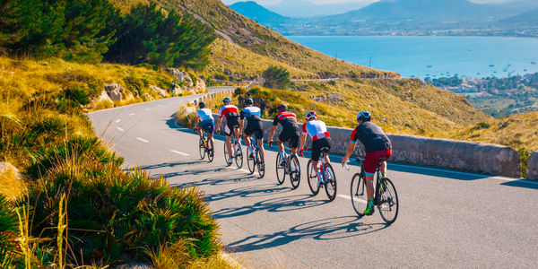 Sporty friends on bicycle on sunset light in beautiful nature by the sea. Road cycling on the coast. Sport in Nature background. Teamwork concept photo
