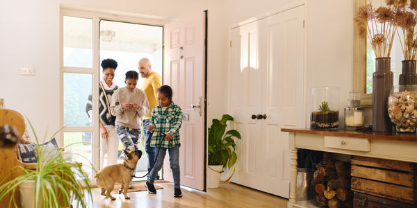 Family arriving home, boy with Down syndrome with dog