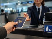 A blue passport is handed over at an airport counter.