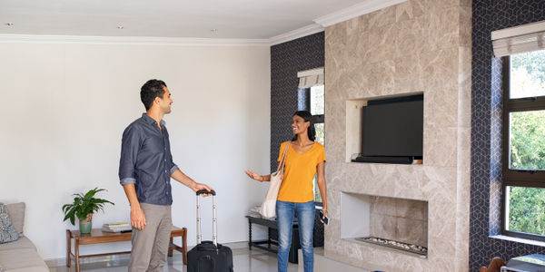 Young man and beautiful woman arrive in vacation rental apartment.