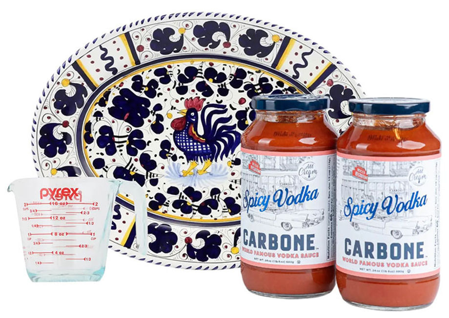 A decorative ceramic plate set with a blue and white rooster pattern sits beside tomato sauces.