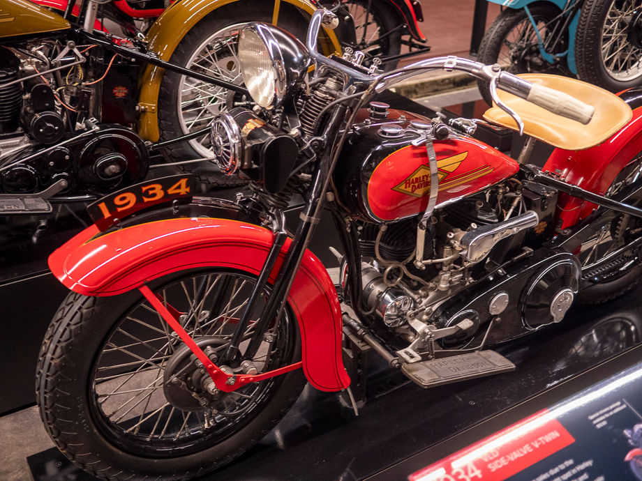 A red vintage motorcycle on display among other classic bikes.