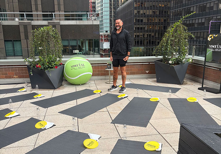 a trainer standing among yoga mats for an exercise class