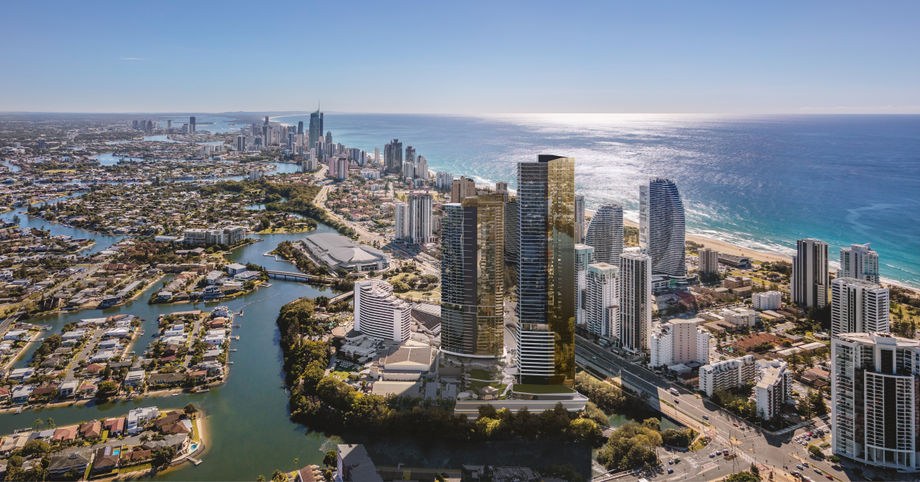 Aerial view of a coastal city with high-rises along the sunny shoreline.
