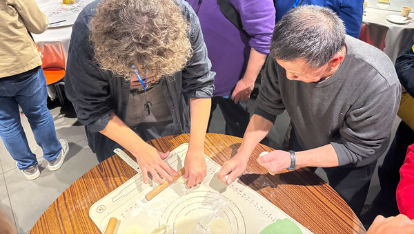 Travel advisors practice making dumplings while on a fam in Beijing.