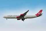 A Virgin Atlantic Airbus a340-300 flies in a clear blue sky.