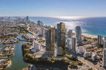 Aerial view of a coastal city with high-rises along the sunny shoreline.