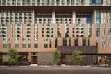 The exterior of Denū Hotel & Spa in downtown Phoenix, with contemporary architecture, large glass windows and a pedestrian-friendly streetscape.