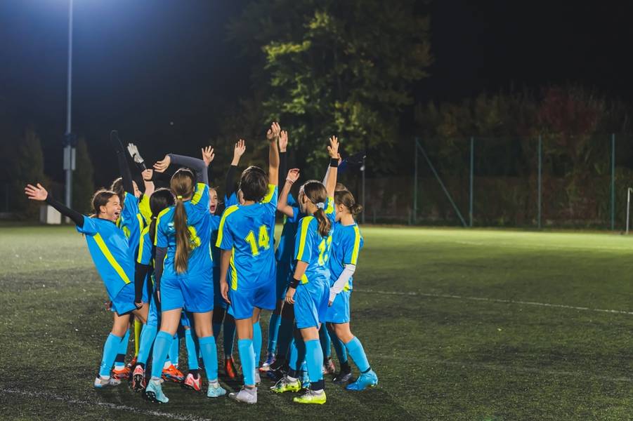 teenage girls football team preparing for match and encouraging each other,