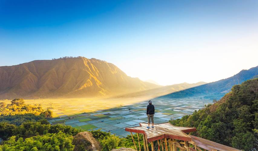 Traveller enjoying views wonderful farmland scenery at Sembalun near Rinjani volcano in Lombok, Indonesia.