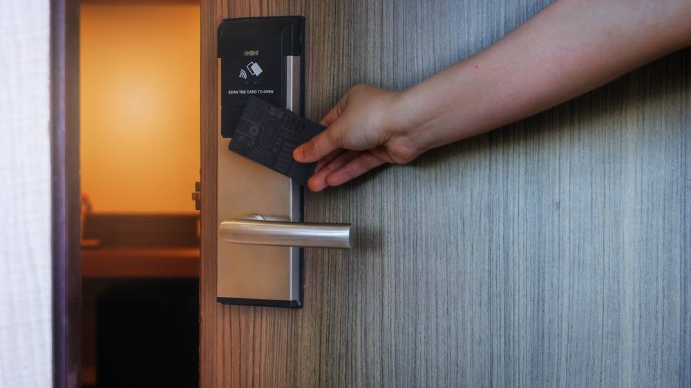 Smart card door key lock system in hotel. Hotel electronic lock on wooden door.