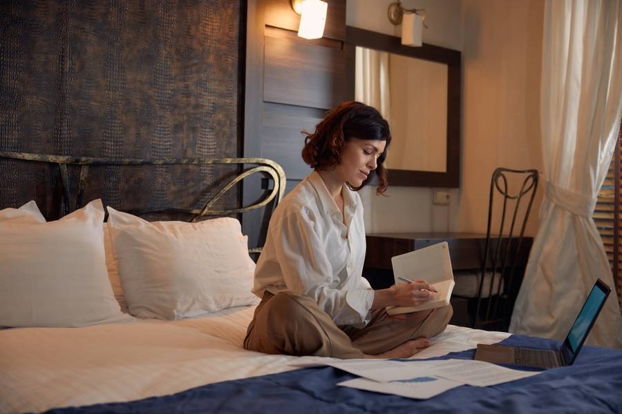 Busy young businesswoman working online from hotel room