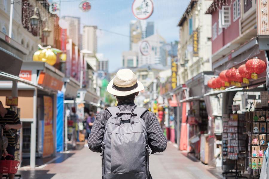 Young man hipster traveling with backpack and hat