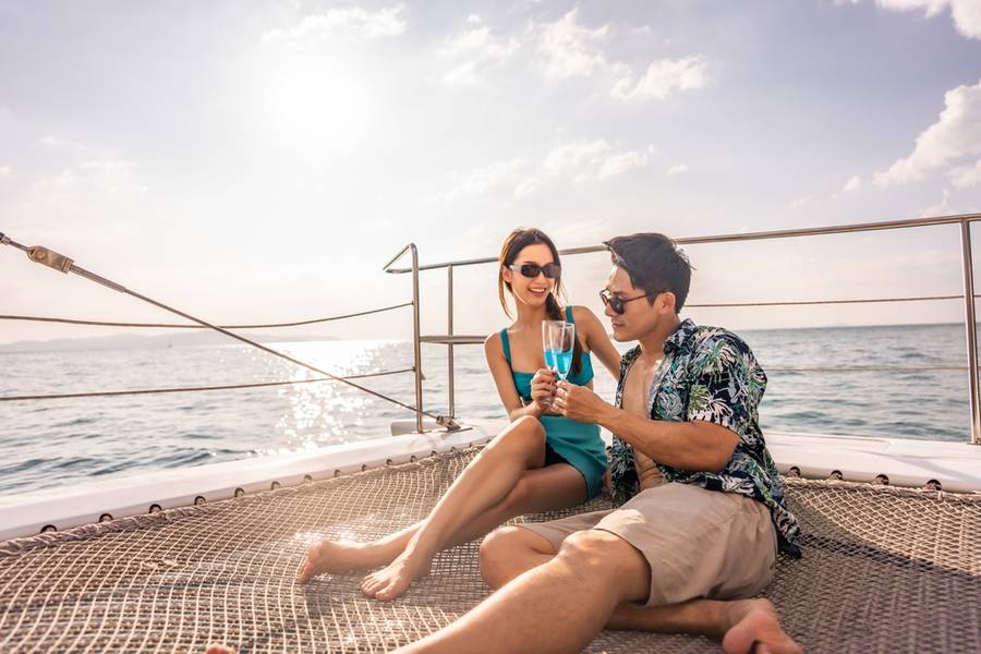 Asian beautiful couple drinking champagne while having party in yacht.