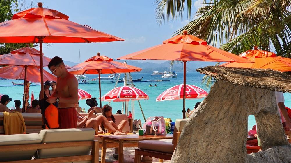  Beach club on the beach in Thailand, umbrellas and deck chairs on the background of the sea coast