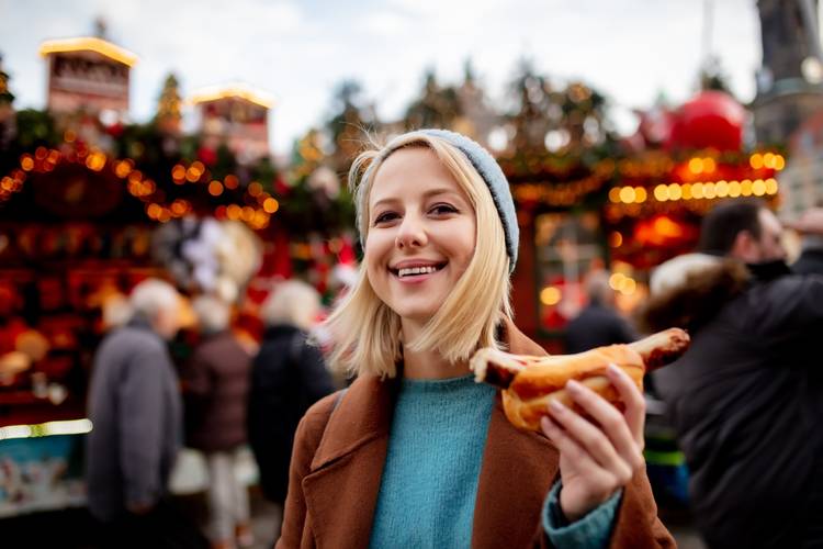 blonde woman with hot dog at the Christmas market in Dresden, Germany