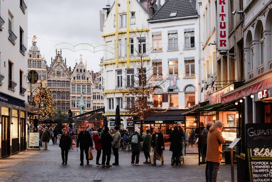 Evening view of the city center is illuminated by Christmas lights, historical buildings in the background, and a Christmas tree