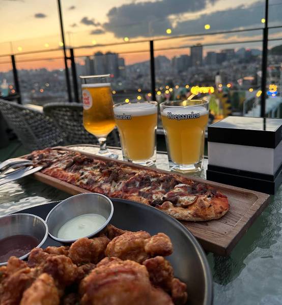 Noop Cafe với cửa kính lớn để ngắm hoàng hôn và cảnh đêm rực rỡ.