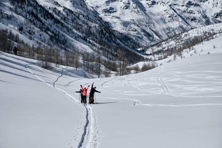 Forested mountain covered in snow and people hiking in col de la lombarde