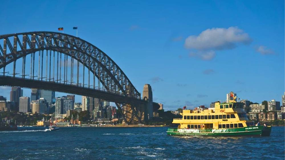 A Sydney Ferry passing by the Sydney harbour Bridge