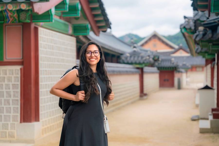 Young happy Latina woman smiling in Seoul temple courtyard in Gyeongbokgung Palace, South Korea