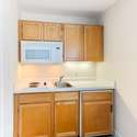 2nd floor Guest Suite kitchenette with built in cabinets, sink, stove, microwave and refrigerator.