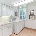 Laundry room with utility sink off garage. Washer and dryer convey.