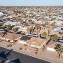 A captivating neighborhood view featuring well-maintained homes surrounded by mature palms and desert plants. This peaceful Sun City West neighborhood offers a picture-perfect backdrop for Arizona living.