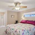 This cozy and inviting bedroom features a ceiling fan, neutral tones, and a private en-suite bath. A perfect space to unwind.