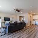 A bright and open living space featuring recessed lighting, wood-look laminate flooring, and a ceiling fan. Ideal for entertaining in a comfortable and stylish setting.