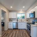 The modern kitchen features shaker-style white cabinetry, a large window for natural light, and high-end finishes. A stylish and practical space for any homeowner.