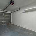 A spacious two-car garage featuring a durable door, ample storage options, and convenient access to the home. Perfect for vehicles and additional storage.
