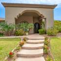 From its well-manicured lawn to its sculpted flower beds, this Scottsdale gem greets you with vibrant curb appeal and desert charm. The wide entry path and elevated porch create a warm, welcoming first impression in this gated community.