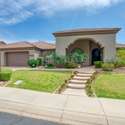 Showcasing arched architecture, a tiled roofline, and triple-car garage, this home stands out in the desirable Sonoran Arroyos. The entry is framed by tropical greenery and updated desert landscaping for a polished, upscale feel.
