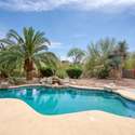 Dive into serenity in a sparkling pool nestled among palms, flowering shrubs, and natural stone accents. This reimagined backyard oasis blends luxury and relaxation with stunning Arizona surroundings.