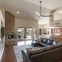 Designed for connection and comfort, this great room features vaulted ceilings, a curved stone fireplace, and fluid access to the kitchen and backyard ideal for both daily living and entertaining guests.