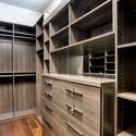 Custom California Closets maximize space with tailored shelving, drawers, and storage in this high-end primary closet. Elegant and efficient design perfect for organized living.