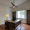 A private, flexible space with hardwood floors, ceiling fan, and tranquil backyard views ready to be your home office, library, or extra bedroom.