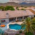 A serene backyard retreat with a shimmering pool, covered lounging space, and vibrant plantings Scottsdale outdoor living at its best.