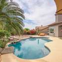 Discover a serene backyard setting with lush green space, mature trees, and privacy landscaping. This versatile outdoor area is ideal for family fun, pets, or future customization in sunny Arizona.