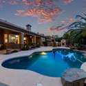 Soak in the luxury of your private resort-style pool as the desert sky glows with rich sunset colors. This inviting backyard in Scottsdale offers seamless indoor-outdoor living with a spacious covered patio and lush landscaping that wraps around the sparkling water feature.