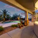 Step outside to a beautifully shaded patio overlooking the pool and vibrant desert landscaping. Framed by architectural columns and blooming flora, this covered space invites relaxed mornings and peaceful evenings in Arizona s mild climate.
