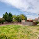 Enjoy outdoor gatherings in this generous backyard space featuring a grassy lawn and built-in BBQ station. With mature landscaping and stone-accented finishes, the area is ideal for entertaining or playing under the Arizona sun.