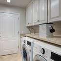 This freshly updated laundry room is as practical as it is polished, featuring granite countertops, abundant cabinetry, and modern LG appliances. Bright, clean, and functional this space makes daily chores a breeze.