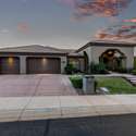 The beautifully landscaped entryway glows beneath a painted sky. This front elevation offers a perfect mix of warmth, privacy, and desert elegance ideal for buyers looking for serene Arizona living.