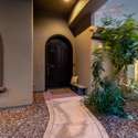 Enjoy Arizona evenings under the shaded entryway of this stylish home. A curved path, potted plants, and subtle lighting combine to create a warm, welcoming feel for residents and visitors alike.