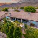 This elevated view captures a beautifully maintained backyard featuring a sparkling pool, shaded patio, and built-in BBQ, all set against striking mountain scenery. Located in one of Arizona s premier neighborhoods, this home offers a seamless blend of luxury amenities, energy-efficient design, and tranquil outdoor spaces perfect for year-round enjoyment.
