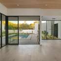 Wall-to-wall glass and natural wood accents make this main living space a showcase of light and flow. Overlooking the pool, it s the heart of indoor-outdoor living in Phoenix.